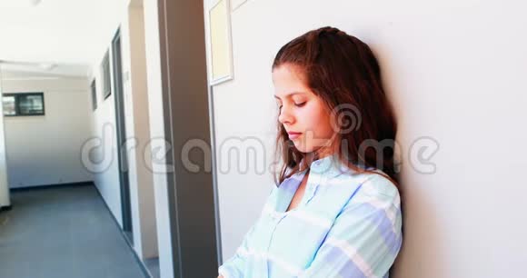 悲伤的女学生坐在走廊里视频的预览图