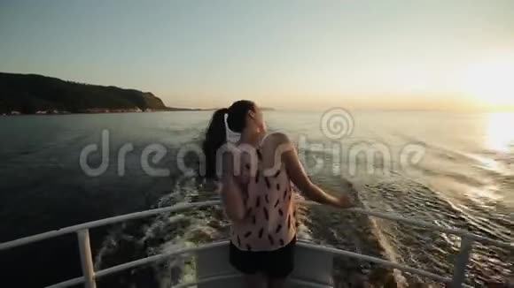 一个美丽的女孩站在船首的后景看着山河天的美丽景观视频的预览图