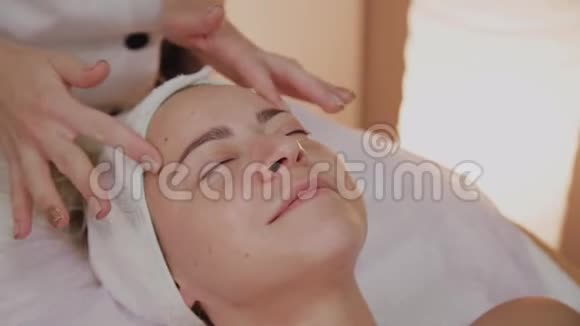 美容师在女人脸上涂霜视频的预览图