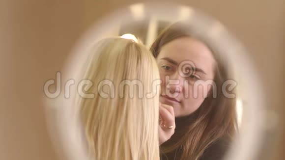 化妆师为镜子里的女孩化妆视频的预览图