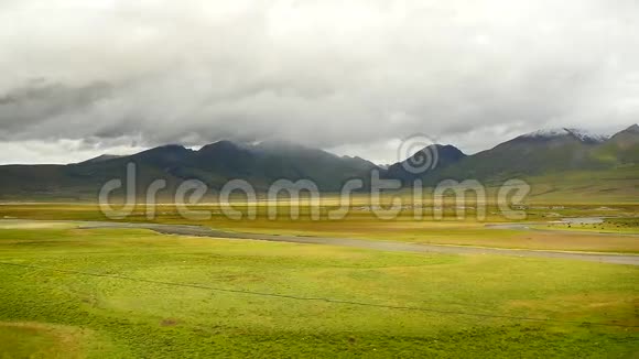 云团滚滚越过西藏山河流流经草原视频的预览图