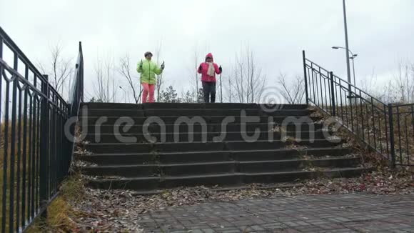 两位老年妇女在秋天公园户外北欧散步视频的预览图