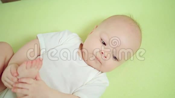 婴儿躺在婴儿床上吃脚趾视频的预览图