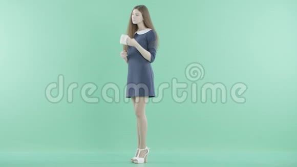 一个漂亮的女人站在那里喝茶视频的预览图