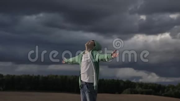 男孩向天空举起双手看着太阳刮风的天气视频的预览图