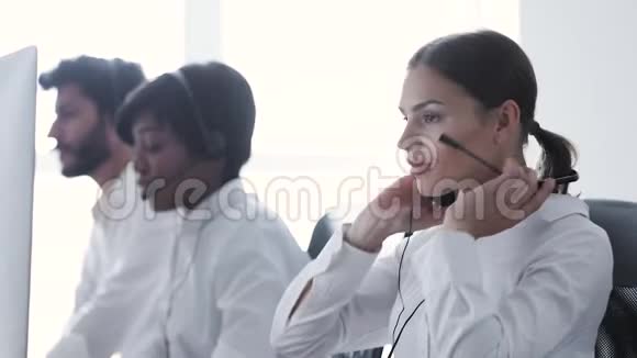呼叫中心在电脑工作的头戴微笑的女人视频的预览图