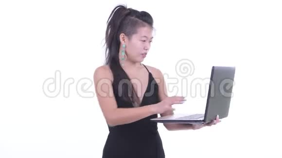 快乐美丽的亚洲女人思考笔记本电脑视频的预览图