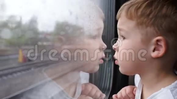 好奇的男孩从火车窗外看进来视频的预览图