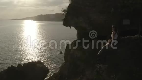 日出时在海边悬崖上慢跑早晨休息后的鸟瞰图视频的预览图