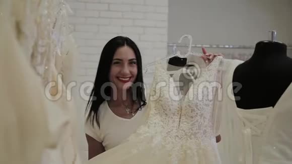 美丽的女孩选择婚纱在新娘沙龙视频的预览图
