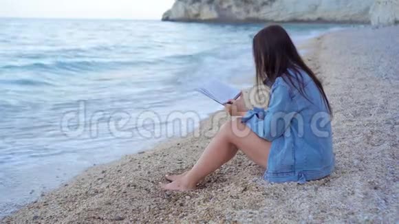在热带白色海滩读书的年轻女子视频的预览图