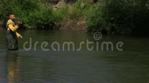 男渔夫抛了一个浮子在河上钓鱼站在水里视频的预览图
