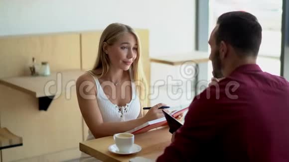年轻情侣坐在咖啡馆里喝咖啡视频的预览图