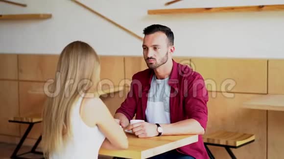年轻情侣坐在咖啡馆里喝咖啡视频的预览图