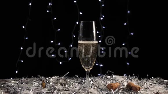 好香槟酒手从桌上拿一杯金色的起泡葡萄酒上面有白雪和彩纸屑视频的预览图