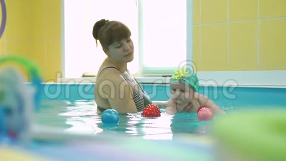 游泳教练与可爱的婴儿在游泳池视频的预览图