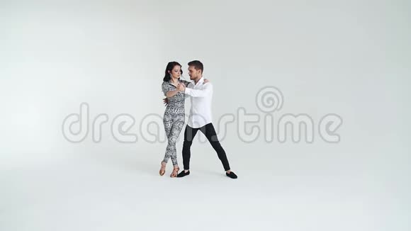爱人际关系和社交舞蹈的概念年轻漂亮的一对在白色背景下跳性感舞蹈的夫妇视频的预览图
