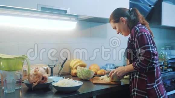 厨房里的女人准备一顿饭的生活方式概念厨房里的女孩用刀切卷心菜做素食者视频的预览图
