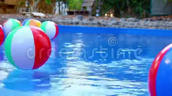 五颜六色的沙滩球漂浮在游泳池里视频的预览图
