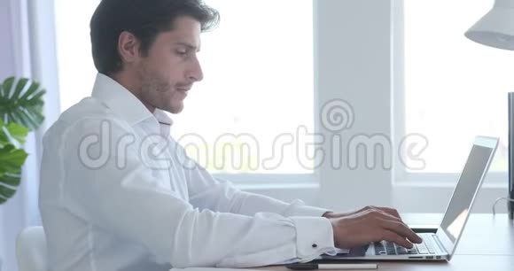 商人在办公室用笔记本电脑打字视频的预览图
