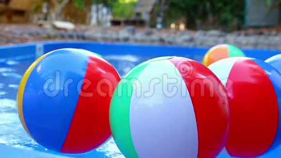 五颜六色的沙滩球漂浮在游泳池里视频的预览图
