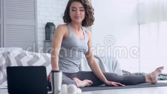 年轻女子在家做瑜伽锻炼视频的预览图