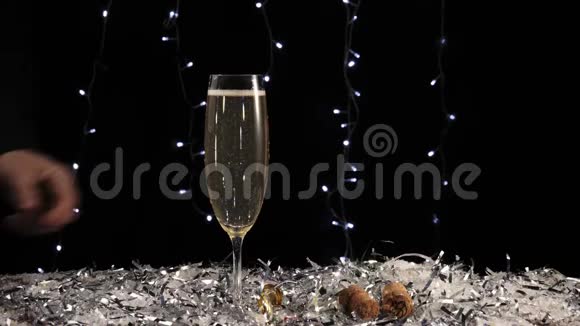 好香槟酒手从桌上拿一杯金色的起泡葡萄酒上面有白雪和彩纸屑视频的预览图