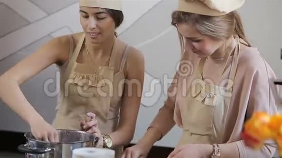 两个年轻女人正在准备纸杯蛋糕视频的预览图