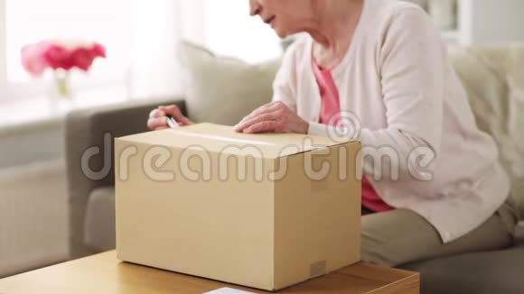 年长妇女在家打开包裹盒视频的预览图