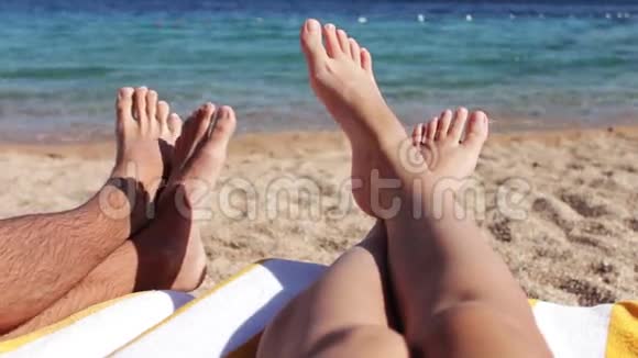 腿躺在沙滩上的阳光休息室视频的预览图