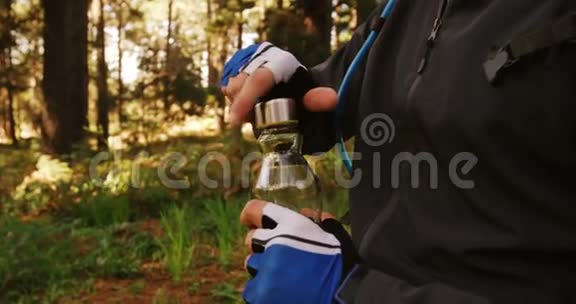 森林中的男性山地车司机饮用水视频的预览图