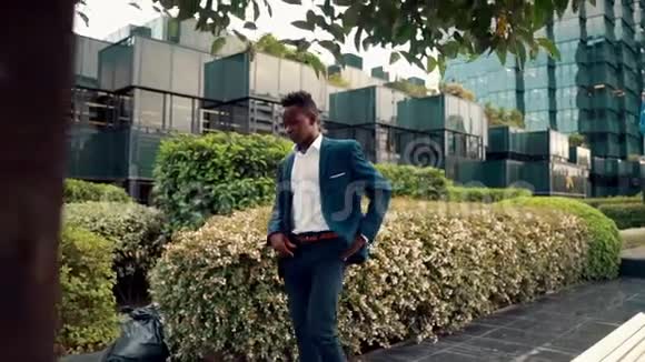 穿着蓝色西装走路的美国黑人商人视频的预览图