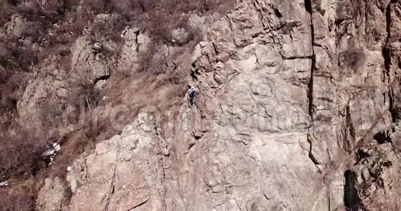 登山者爬上岩石女孩和男孩爬上岩石攀岩课视频的预览图