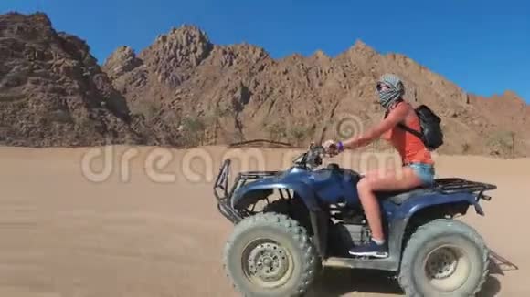 性感的女人在埃及沙漠骑着四人自行车动中的动态视图视频的预览图