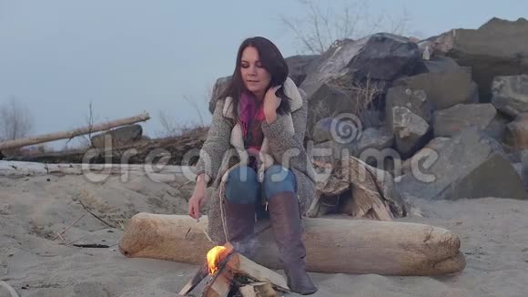 晚上坐在火炉旁的年轻女子视频的预览图