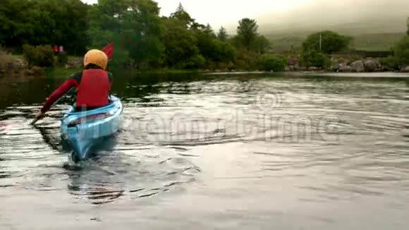 女人在乡村的湖里皮划艇视频的预览图