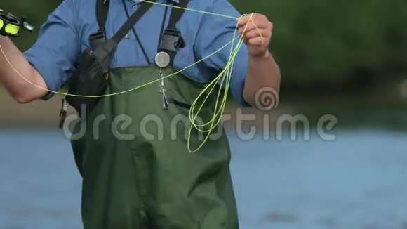 渔夫拿着鱼竿抛着一个浮子在河里钓鱼视频的预览图