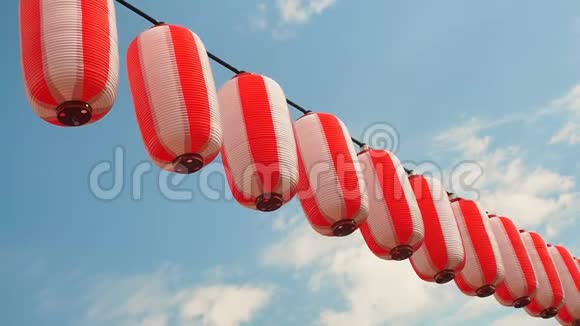 悬挂在蓝天背景上的日本红白灯笼视频的预览图