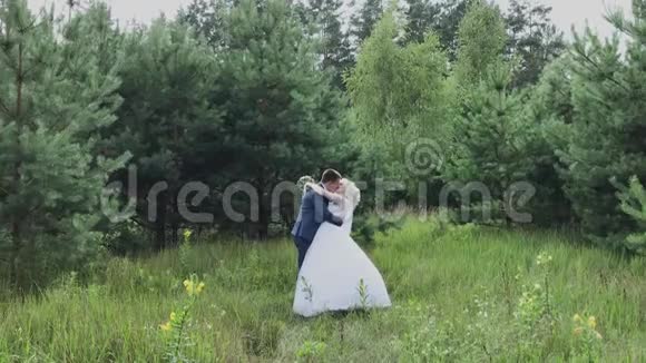 非常漂亮的新娘和新郎在森林里牵手拥抱视频的预览图