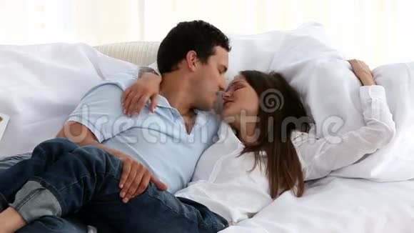 快乐的一对夫妇躺在沙发上拥抱在一起视频的预览图