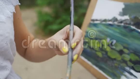公园里的女画家用油画画了一个小池塘视频的预览图