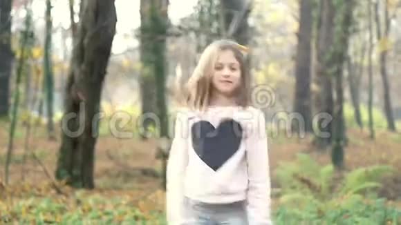 在公园里玩扔树叶和跳跃的女孩视频的预览图