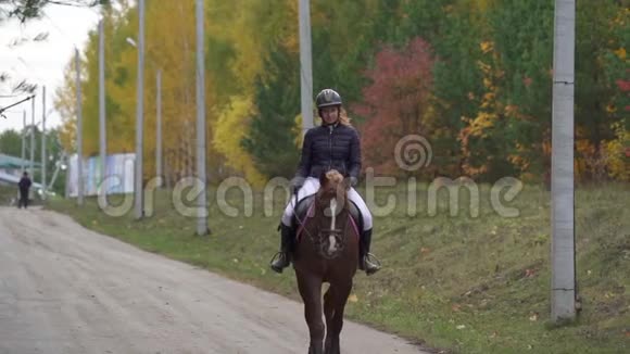 一位骑在马上的漂亮女骑师的肖像各项比赛之间的突破视频的预览图