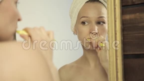 年轻的美女头上戴毛巾在浴室刷牙视频的预览图