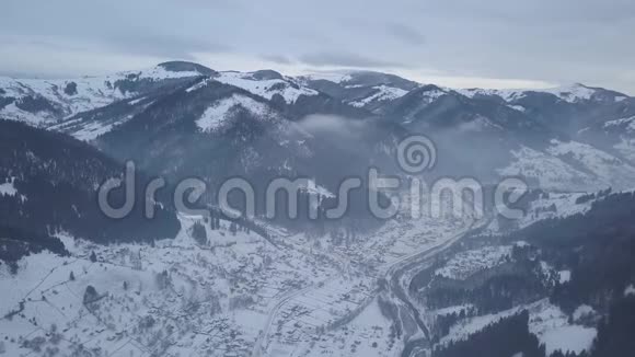 喀尔巴阡山上白雪覆盖的克里沃维尼亚山村鸟瞰视频的预览图