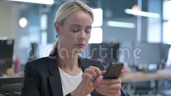 年轻的女商人在工作中使用智能手机视频的预览图