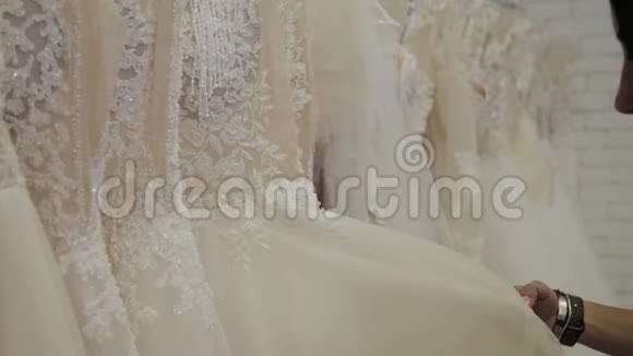美丽的女孩选择婚纱在新娘沙龙视频的预览图