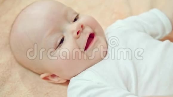 婴儿躺在柔软的亚麻布上微笑视频的预览图