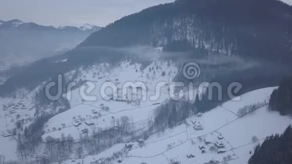喀尔巴阡山上白雪覆盖的克里沃维尼亚山村鸟瞰视频的预览图