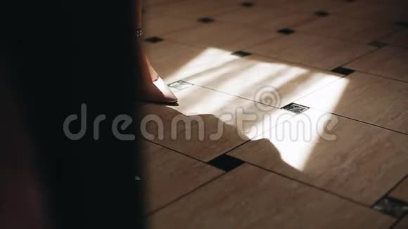 女性的双脚特写镜头在白天从窗户穿过相机视频的预览图